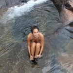 Seven Wells Waterfall in Langkawi Malaysia, sitting under the waterfall- me in the rock pool facemadeup.com